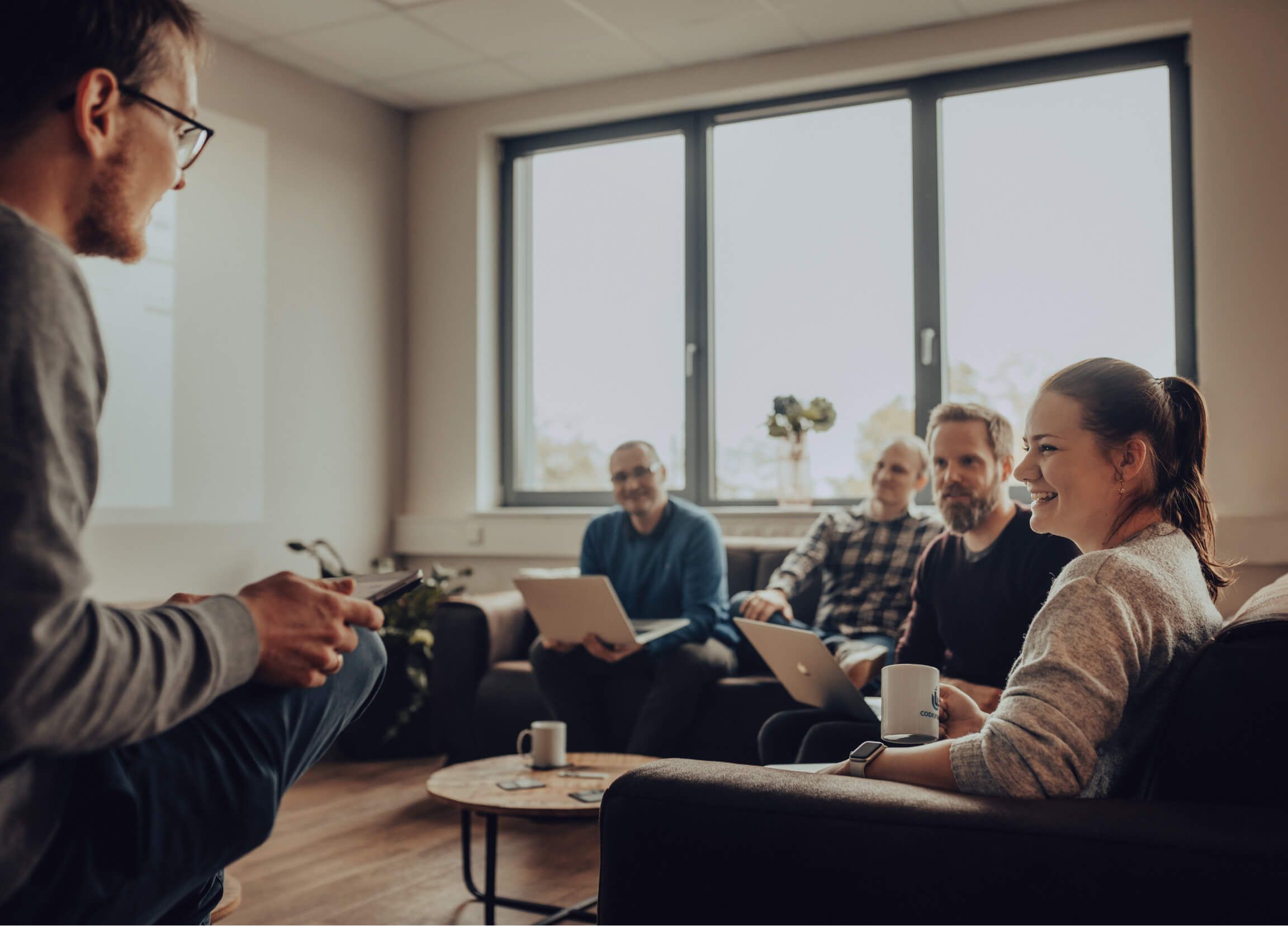 A team of software developers in conversation in a lounge area